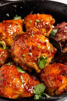 chicken wings with sauce and parsley in a cast iron skillet, ready to be eaten