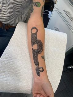 a person with a tattoo on their arm holding a knife in one hand and scissors in the other