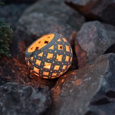 a lit candle is sitting on some rocks