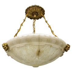 a white and gold chandelier hanging from a ceiling fixture with two golden chains