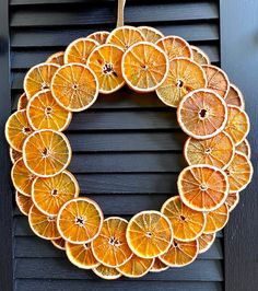 an orange wreath hanging on the side of a door with other oranges around it