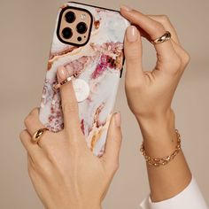 a woman holding up her phone case to show it's marble design on the back