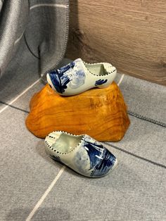 two pairs of shoes sitting on top of a piece of wood next to a chair