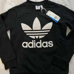 Brand New Adidas Pullover. Size Medium Black Sports T-shirt, Black Sporty Sweater With Letter Print, Sporty Black Sweater With Letter Print, Basic Long Sleeve Sweatshirt With Logo Print, Black Casual Sweater With Logo Print, Casual Black Sweater With Logo Print, Basic Adidas Logo Crew Neck Tops, Basic Adidas Crew Neck Tops, Adidas Logo Long Sleeve Sweatshirt For Fall