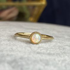 Handcrafted in 14K solid gold, features a 4mm round cab natural opal bezel set in a beautiful milgrain vintage style setting. A great everyday stacking ring or alternative gemstone engagement ring for your loved one! 🛠️ Setting: ✔️Metal Purity: 14K Solid Gold ✔️Color:  Yellow ✔️Band width: 1.5mm ✔️Ring sits 2.7mm on the finger 💎Center Stone: ✔️Stone: Natural Opal ✔️Shape: Round Cabochon ✔️Size: 4mm ✔️Carat: 0.25ct ❤️Visit our official website for exclusive new products.      https://elekalonjewelry.com/ ❤️Follow us on Instagram @ elekalonjewelry for the latest projects and much more! ❤️If you have any questions, please feel free to message us. . Gold Opal Birthstone Ring, Gold Opal Ring With Birthstone, Gold Ethiopian Opal Birthstone Ring, 14k Yellow Gold Opal Ring Birthstone, Heirloom Style Gold Opal Ring With Bezel Setting, Heirloom Gold Opal Ring With Bezel Setting, Gold Opal Ring Adjustable, Gold Opal Ring With Bezel Setting, Gold Adjustable Opal Ring, Round Shape