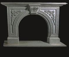 a white fireplace with an ornate design on the top and bottom, against a black background