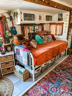 a bed with lots of pillows on top of it in a room filled with rugs