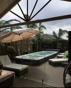 an outdoor hot tub and lounge chairs on a deck