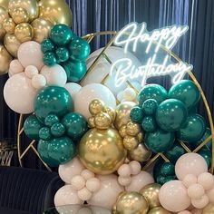 the balloon arch is decorated with gold, white and teal balloons that spell out happy birthday