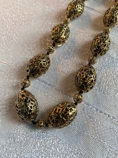 Vintage Monet gold tone filigree bead necklace  Quality piece, heavy and substantial  It measures 24 inches long inc the extender chain  In excellent condition, beads are knotted onto cord Oval beads approx 20 mm x 13 mm in size Vintage Gold Beads For Festive Occasions, Gold Beaded Metal Necklace, Gold Metal Necklace With Polished Beads, Gold Necklace With Polished Metal Beads, Gold Beaded Necklace With Large Beads For Festive Occasion, Festive Vintage Gold Beads, Vintage Gold Polished Beads, Vintage Polished Gold Beads, Vintage Large Gold Beads