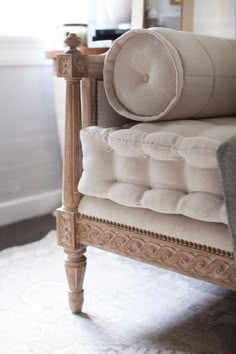 an upholstered chair with pillows on it