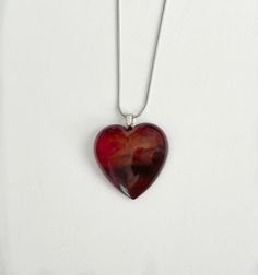 This sophisticated Bodacious Heart Necklace is the perfect finishing touch to any ensemble. Intricately crafted with 18" of sterling silver chain, resin and mica powders, it stands out with bold coloring and eye-catching attention. Custom colors are available with request, and pairing with the Bodacious Heart Ring completes the look. Check out our Bodacious Heart Ring. Unique Red Heart-shaped Necklace, Resin Heart Charm Pendant Jewelry, Red Pendant Necklace For Keepsake, Red Keepsake Pendant Necklace, Red Resin Pendant Necklaces, Red Resin Pendant Jewelry, Big Heart Necklace, Phone Items, Next Clothes