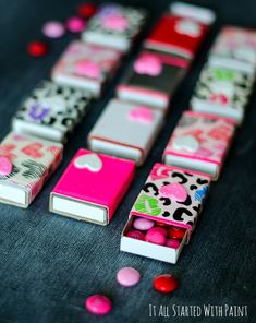 several small pink and white boxes with candy in them