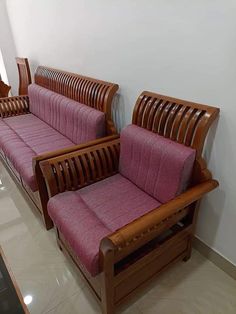 two wooden couches sitting next to each other in a room