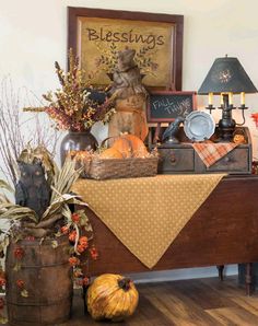 a wooden table topped with lots of pumpkins and other decorating items on top of it