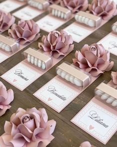 there are many pink flowers on the table with place cards in front of each other