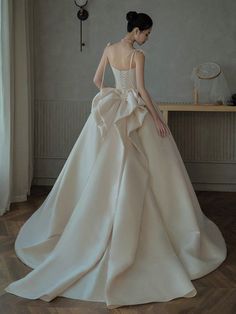 a woman in a wedding dress looking down at the floor