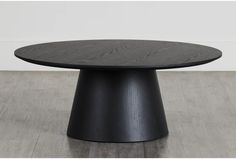 an oval table with black wood grained finish on the top and bottom, sitting on a hard wood floor