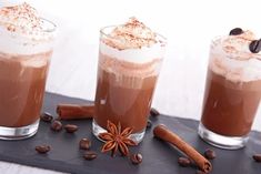 three glasses filled with hot chocolate and cinnamon