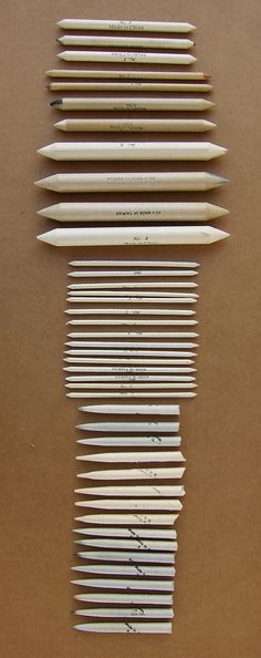 several pencils lined up on top of each other in different sizes and shapes with writing underneath them