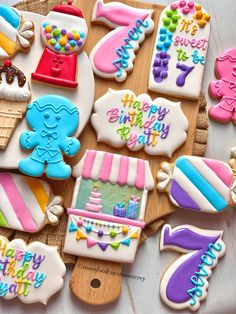 decorated birthday cookies on a wooden board with the words happy birthday written in large letters