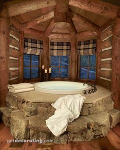 a log cabin bathroom with a large jacuzzi tub and stone steps leading up to the window