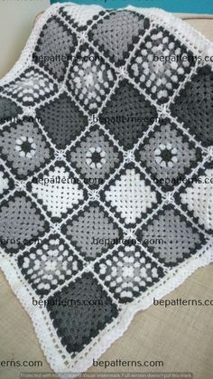 a crocheted afghan is sitting on a couch with the pattern in black and white