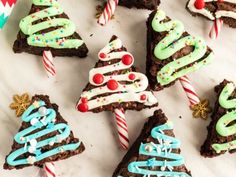 christmas brownies decorated with icing and candy canes on a white tablecloth