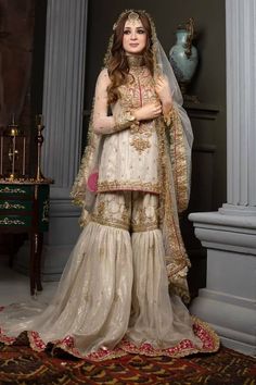 a woman in a wedding outfit posing for the camera