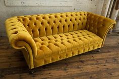 a yellow couch sitting on top of a wooden floor