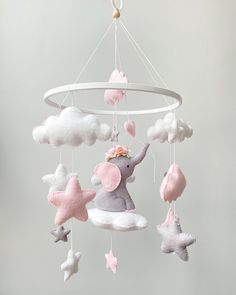 a baby mobile with an elephant and stars hanging from it