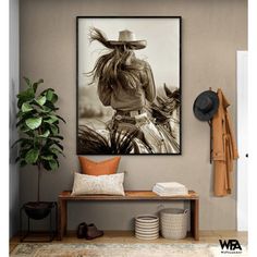 a black and white photo of a woman with a cowboy hat hanging on the wall