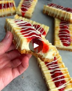 someone is holding some kind of dessert with jelly on it's crust and drizzled in white icing