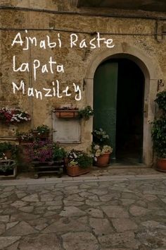 an old building with flowers and potted plants on the outside wall that says amalfiraste la pato manziliy