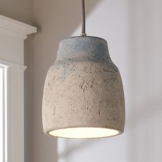 a light that is hanging from a ceiling in a room with white walls and windows