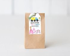 a brown paper bag with a princess sticker on the front and an image of a tractor behind it