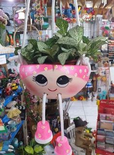 a potted plant hanging from the ceiling in a store filled with toys and other items