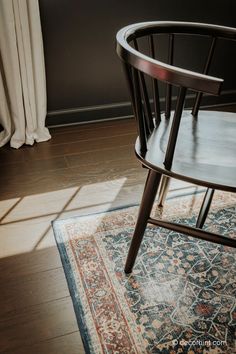 a chair sitting on top of a wooden floor next to a window