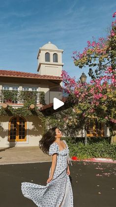 a woman is walking in front of a house