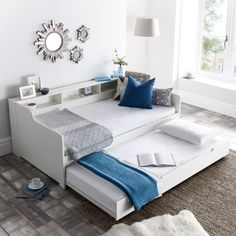 a white daybed with blue pillows in a living room