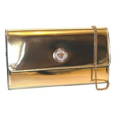 Elevate your evening ensemble with this Versace La Medusa crossbody clutch bag. The reflective gold patent leather complements the iconic La Medusa logo plaque, embedded with white crystals for a luxurious finish. The bag securely fastens with a snap button closure, revealing a chic black fabric interior equipped with 10 card slots and a central zip compartment for effortless organization. Carry it as a sophisticated clutch or utilize the elegant gold chain shoulder strap for versatile styling. Evening Clutch Bag With Logo Plaque, Classic Gold Bags With Logo Plaque, Luxury Formal Bags With Logo Plaque, Luxury Formal Bag With Logo Plaque, Evening Clutch Bags With Logo Plaque, Gold Evening Bag With Logo Plaque, Elegant Rectangular Bag With Logo Plaque, Gold Bag With Metal Logo For Formal Occasions, Classic Gold Clutch For Events