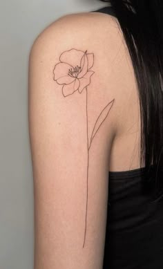 a woman's shoulder with a single flower tattoo on her left upper half arm