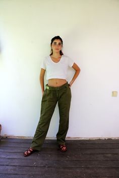 Vintage green military cargo pants, nicely broken in, with a zip-up closure and Velcro straps.  Made of cotton, featuring one large cargo side pocket secured with Velcro straps. Marked 1987. The pants are large in the waist on the model; in some photos, she is holding the sides of the waist, and in others, the waist is folded out. Aside from minor signs of wear, these pants are in good vintage condition, clean, and ready to wear.  The model is 5'7" and size S for reference Approximate size:  oversize fit for most- please refer to the measurements. M E A S U R E M E N T S -were taken with garments laying flat, please double where necessary. ------------------------♥-------- Waist: 18"-45cm Rise: 11.5"-29cm Hips: 22"-56cm Inseam:31.5"-80cm Length: 42"-106cm ---------------------------------- Army Trousers, Cargo Pants Vintage, Military Cargo Pants, Green Field, Pants Vintage, Velcro Straps, Side Pocket, Oversized Fits, Cargo Pants