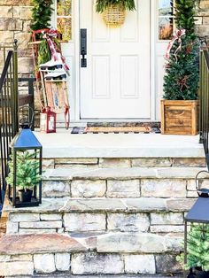 front porch decorated for christmas with wreaths and lanterns