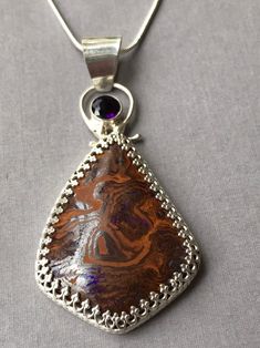 "This is a stunning opal pendant with a purple hue in it. Enhanced with a deep purple 6mm amethyst. Set in a gallery bezel of sterling silver. The opal is approximately 40 x 30 mm. Overall including the bail approximately 2-1/2 x 1-1/4\". Comes with a complementary sterling silver chain, or add your favorite chain. Op211" Purple Opal Gemstone Jewelry, Unique Purple Sterling Silver Gemstones, Silversmithing Jewelry, Boulder Opal Ring, Smoky Quartz Necklace, Amethyst Set, Boulder Opal Pendant, Metal Clay Jewelry, Pretty Pendant