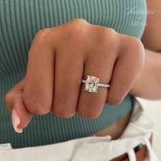 a woman's hand with a ring on her finger and a diamond in the middle