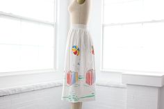 A quaint little 1970s vintage beach themed skirt with smocked elastic wast band. It is sheer so you’ll need a slip, or its perfect for pulling on after a swim. How cute would this be paired with a white, red, yellow, blue, or green bikini? Measurements of garment, allow space for fit.Taken flat, doubled for circumference.Shown on size 4 dress form.Length: 28.5”Waist: 22” to 36”Hips: 46”Swing: 56”Tag: SloganFabric: Polyester, RayonCondition: Excellent vintage. Tiny rust spot shown in photos. Lace Kaftan, Shirtwaist Dress, Skirt Suit Set, Beach Skirt, Pleated Maxi Dress, Skirt Vintage, Pleated Maxi, Beach Themed, Vintage Beach