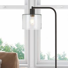 a lamp that is next to a window in a room with white walls and windows