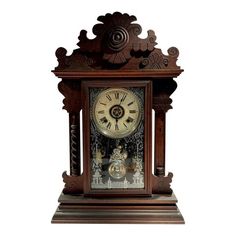 an ornate wooden clock with roman numerals on the face and hands, in front of a white background