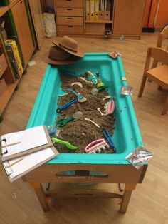 a pool table that is filled with dirt and other things to play in the sand